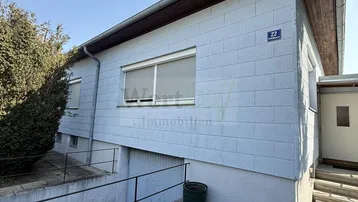 Vorderansicht des Hauses mit Zufahrt zur Tiefgarage und Außentreppe zum Eingang.