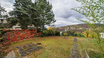 Gepflegter Gartenbereich mit Rasenfläche und Blick auf die umliegende Landschaft.