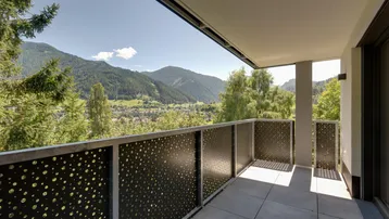 Geräumiger Balkon mit Fliesenboden und modernem Geländer, bietet einen weiten Bergblick.