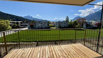 Geräumiger Balkon mit Holzboden und atemberaubendem Panoramablick auf die umliegende Berglandschaft.