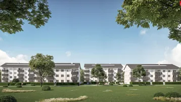 Moderne Mehrfamilienhäuser mit Balkonen, umgeben von weitläufigen Grünflächen und Bäumen unter blauem Himmel.