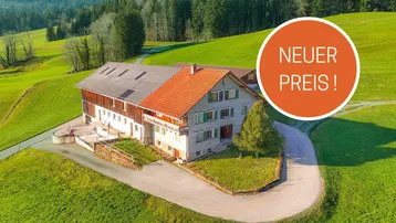 Luftaufnahme eines Bauernhauses in ländlicher Umgebung mit grünen Wiesen und Wäldern.