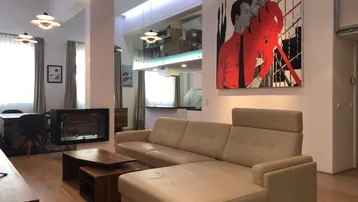 Geräumiger Wohn- und Essbereich mit modernem Kamin, hohen Decken und Zugang zu einer Galerie.
