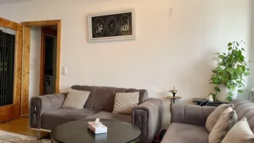 Wohnzimmer mit bequemen Sofas, Holzboden und dekorativem Wandbild.
