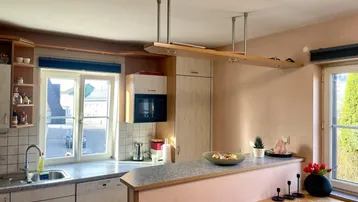 Funktionale Einbauküche mit Fenster, Spülmaschine und Mikrowelle, bietet Blick nach draußen.