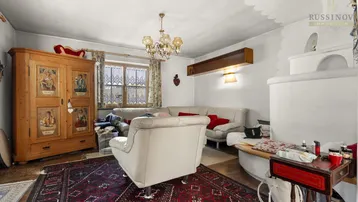 Gemütliches Wohnzimmer mit traditionellen Möbeln, Kamin und einem großen Teppich.