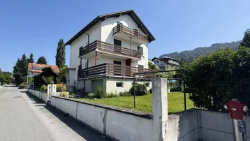 Freistehendes Wohnhaus mit mehreren Balkonen und Gartenbereich in sonniger Lage.