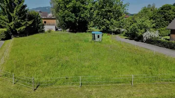 Luftaufnahme eines großen, grünen Grundstücks mit Wiese und umgebenden Bäumen.