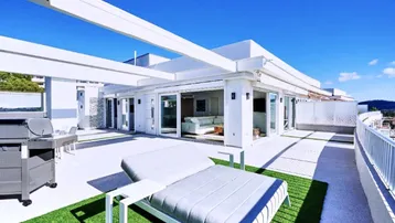 Große Dachterrasse mit Sonnenliegen, Grillbereich und Zugang zum hellen Wohnbereich.