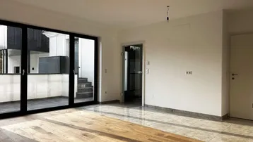 Helles Wohnzimmer mit Holzboden und Fliesen, großen Schiebetüren und Zugang zur Terrasse.