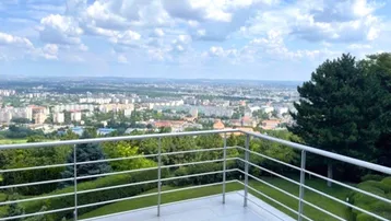 Große Terrasse mit modernem Geländer und weitem Blick über die Stadtlandschaft.