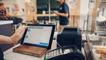 Kassenbereich in einem modernen Café mit Tablet-Kassensystem und Kartenterminal.