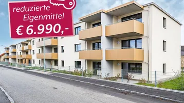 Neues Mehrfamilienhaus mit modernen Balkonen und reduzierten Eigenmitteln, von der Straße aus gesehen.