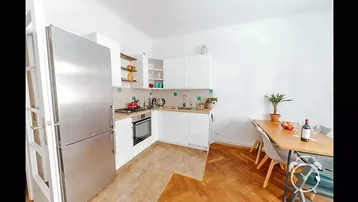 Funktionale Küche mit weißen Schränken, Gasherd und Essbereich, ideal für gemeinsame Mahlzeiten.