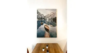 Heller Essbereich mit Holztisch und einem Wandbild, das eine Berglandschaft zeigt.