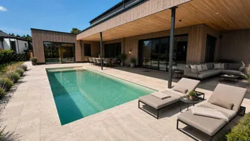 Moderner Außenbereich mit großem Pool, Sonnenliegen und überdachter Terrasse für entspannte Stunden im Freien.