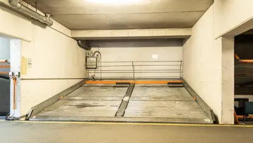 Tiefgaragenstellplatz mit mechanischem Parksystem für zwei Fahrzeuge in einer modernen Anlage.