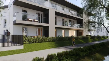 Moderne Wohnanlage mit Balkonen, Glasgeländern und gepflegten Grünflächen entlang eines Weges.