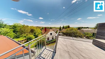 Große Dachterrasse mit Fliesenboden, Metallgeländer und weitem Blick über die ländliche Umgebung.