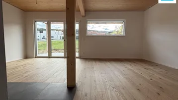 Heller, offener Wohn- und Essbereich mit Holzbalken, Parkettboden und Zugang zur Terrasse.