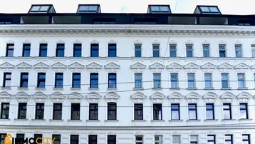 Fassade eines Altbaus mit vielen Fenstern und modernen Dachgauben.