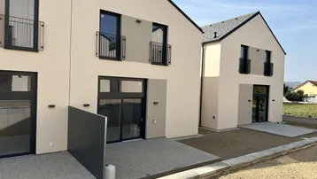 Moderne Reihenhäuser mit Terrassen und französischen Balkonen in einer neuen Siedlung.