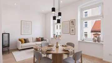 Helles Wohn- und Esszimmer mit modernem Holztisch, bequemer Couch und Parkettboden.