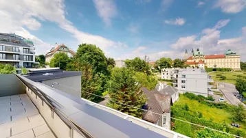 Große Dachterrasse mit weitem Blick über die Stadt und historische Gebäude unter blauem Himmel.