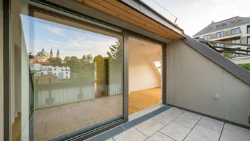 Große Terrasse mit Fliesenboden und weitem Blick über die Stadt und die umliegende Landschaft.