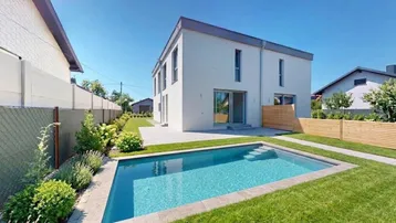 Modernes Einfamilienhaus mit privatem Pool, gepflegtem Rasen und sonniger Terrasse.