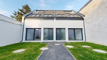 Moderne Doppelhaushälfte im Neubau mit zwei Eingängen und kleinem Vorgartenbereich.