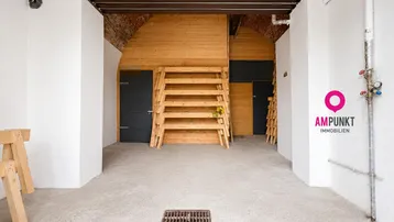 Renovierter Kellerraum mit Holzbögen, Betonboden und weißen Wänden, ideal als Lagerfläche.