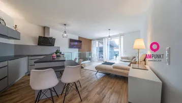 Moderner offener Wohn- und Essbereich mit integrierter Küche und Zugang zur Terrasse.