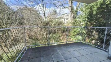 Geräumiger Balkon mit Fliesenboden und Blick ins Grüne, ideal zum Entspannen im Freien.