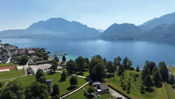 Panoramablick auf den See, die Berge und die umliegende Landschaft mit Sportanlagen.