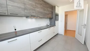 Moderne Küche mit grauen Oberschränken, weißen Unterschränken und integrierten Geräten.