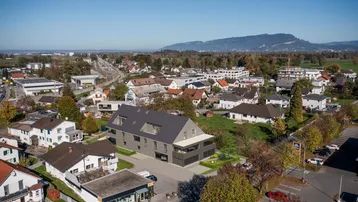 Luftaufnahme des Wohngebäudes in einer ländlichen Umgebung mit Bergen im Hintergrund.