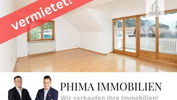 Heller Wohnraum mit Holzboden, großen Fenstern, Zugang zum Balkon und Dachschräge.