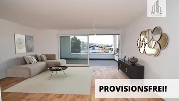 Helles Wohnzimmer mit modernem Sofa, Holzboden und Zugang zu einem Balkon mit Weitblick.