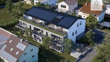 Moderne Wohnanlage aus der Vogelperspektive mit großzügigen Balkonen und Solaranlagen auf dem Dach.