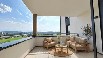 Geräumiger Balkon mit bequemen Outdoor-Möbeln und weitem Blick über die Landschaft.