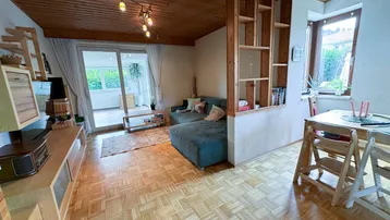 Geräumiger Wohn- und Essbereich mit Holzbalkendecke, Parkettboden und Zugang zur Terrasse.