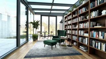 Lichtdurchfluteter Wintergarten mit raumhohen Fenstern, Glasdach und integriertem Bücherregal.