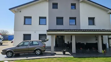 Modernes Einfamilienhaus mit überdachtem Carport und gepflegtem Vorgarten.