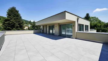 Große, modern geflieste Dachterrasse mit weitem Blick und Zugang zu den Wohnräumen.