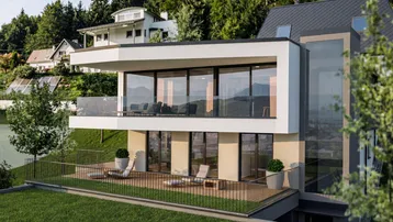 Moderne Villa mit großer Terrasse und Balkon, umgeben von grüner Landschaft und Bergblick.