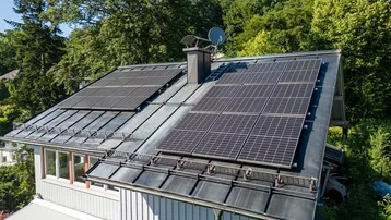 Nahaufnahme des Daches mit installierten Photovoltaik-Modulen zur Energiegewinnung.