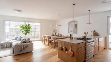 Heller, offener Wohn- und Essbereich mit moderner Küche, Holzboden und Zugang zur Terrasse.