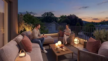 Gemütliche Terrasse mit Lounge-Möbeln und stimmungsvoller Beleuchtung am Abend.
