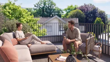 Helle Dachterrasse mit bequemen Loungemöbeln und weitem Blick ins Grüne.